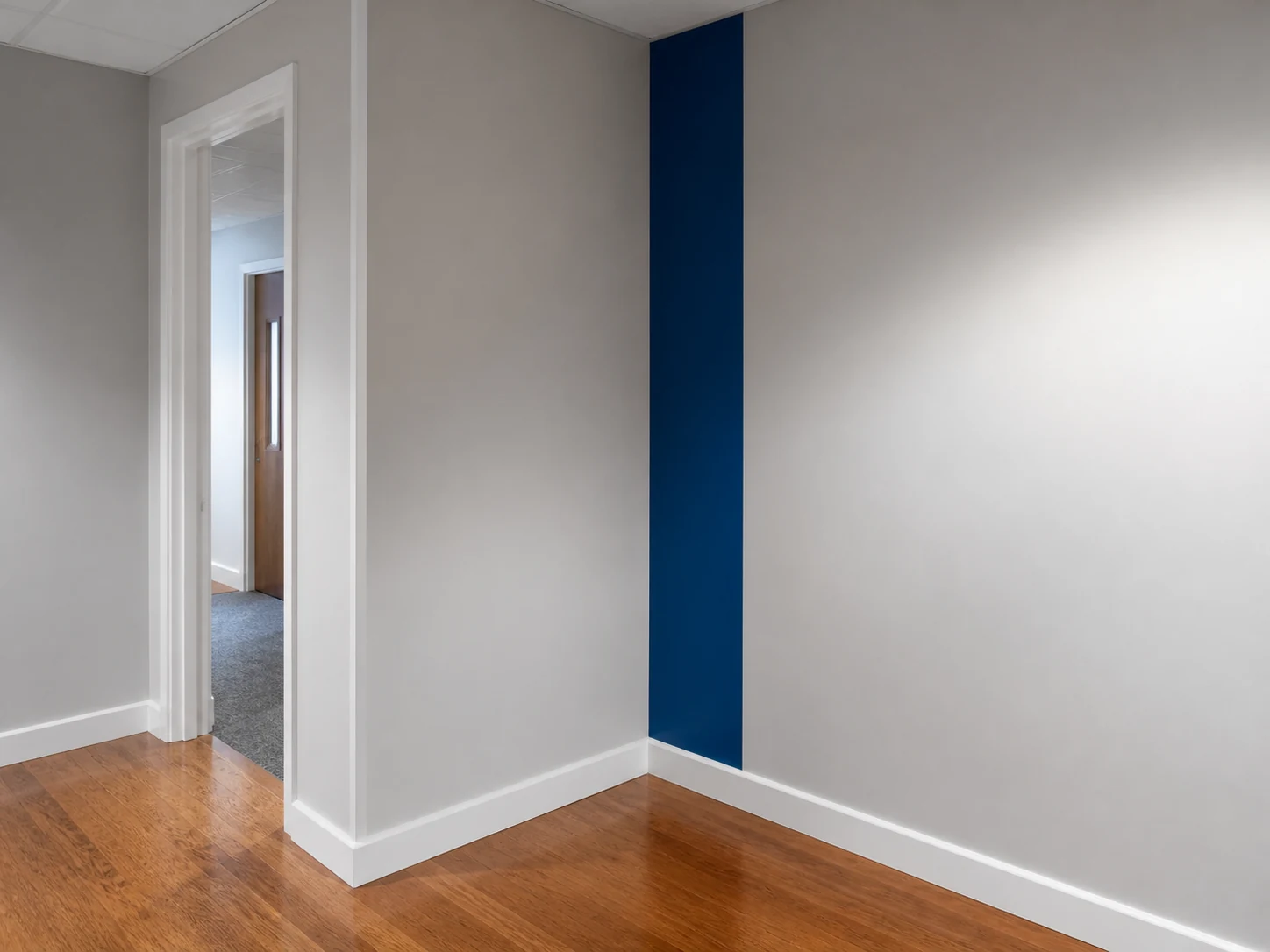 Finished office corridor with consistent walls, trim and blue accent detail